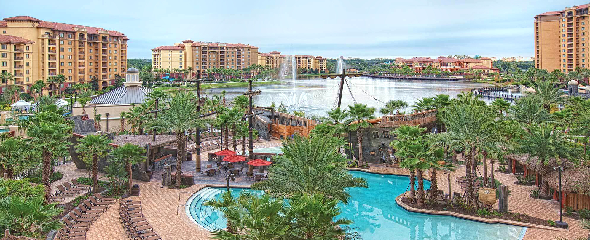 View of lake, pool, and pirate ship at Club Wyndham Bonnet Creek resort in Orlando, Florida.