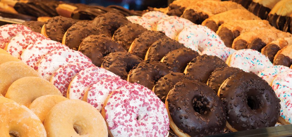 A large display of frosted sprinkles and glazed doughnuts on National Doughnut Day